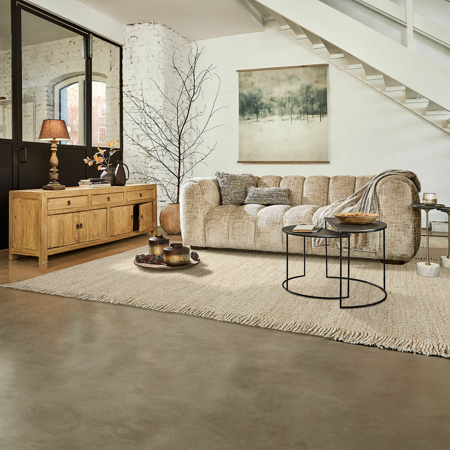 Tapis Levraut Canapé beige en tissu dans un salon moderne avec buffet en bois et tables basses en métal noir
