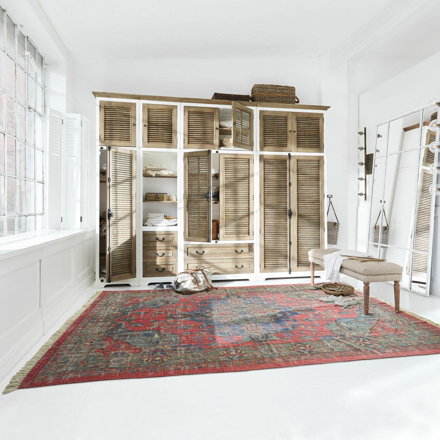 Tapis Southampton Grand tapis rouge à motif oriental sur sol blanc dans une pièce lumineuse avec armoire en bois