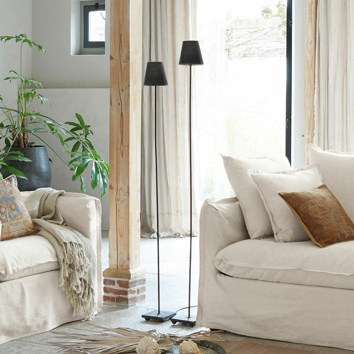 Staande lamp set van 2 Tacoma Twee zwarte metalen vloerlampen in lichte woonkamer met beige bank en groene plant