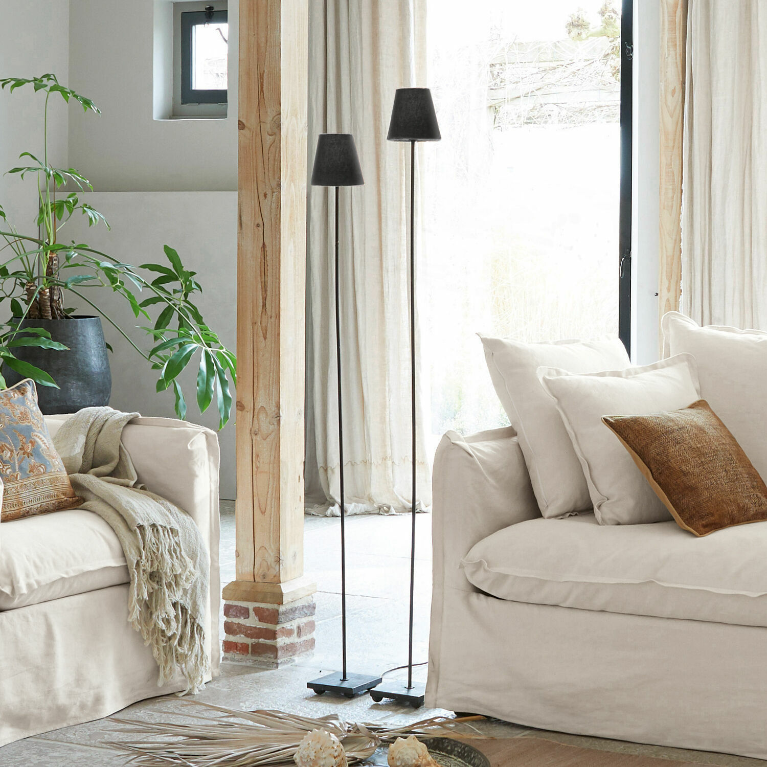 Staande lamp set van 2 Tacoma Twee zwarte metalen vloerlampen in lichte woonkamer met beige bank en groene plant