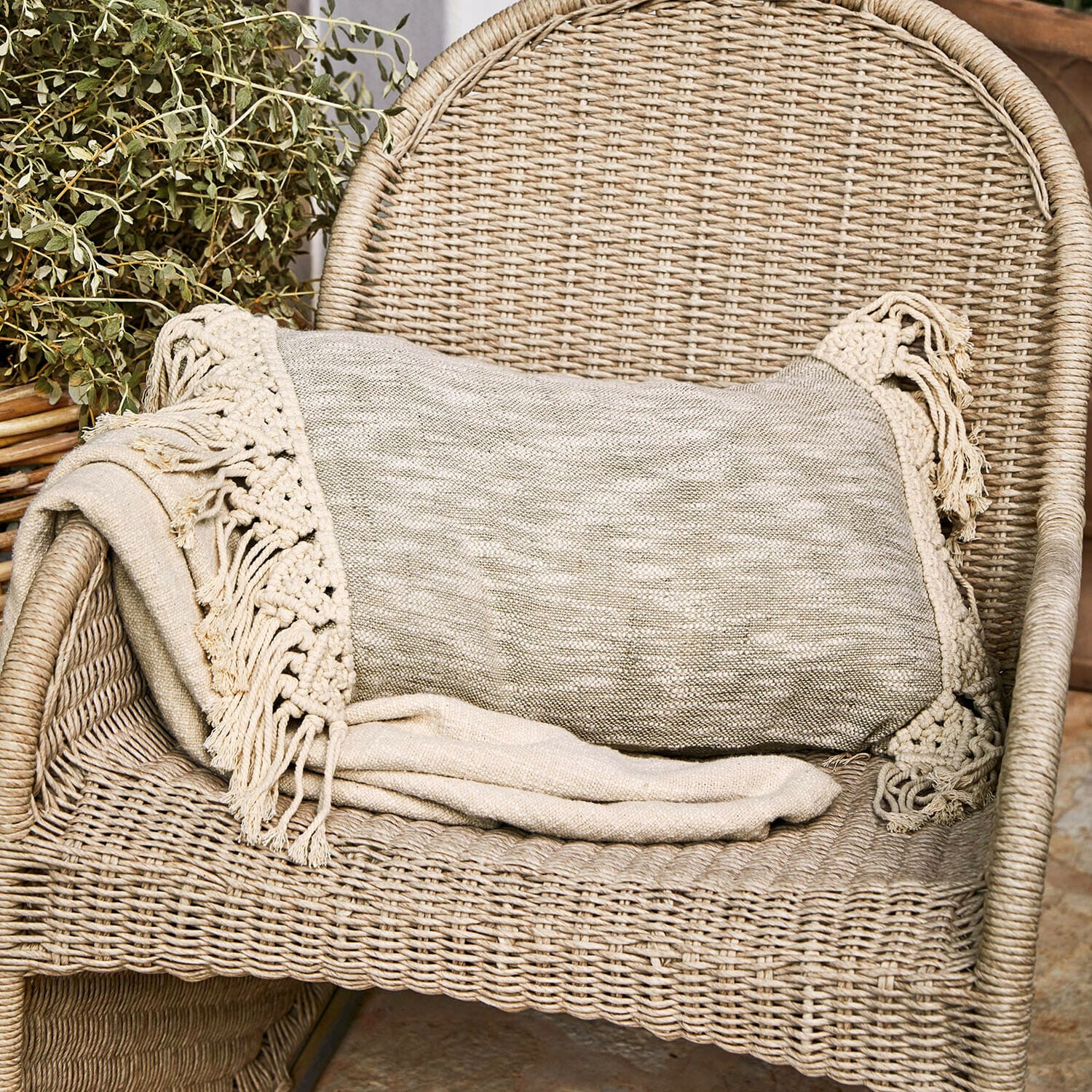 Housse de coussin Dunlora Plaid beige avec franges sur fauteuil en osier, décoration intérieure chaleureuse et confortable