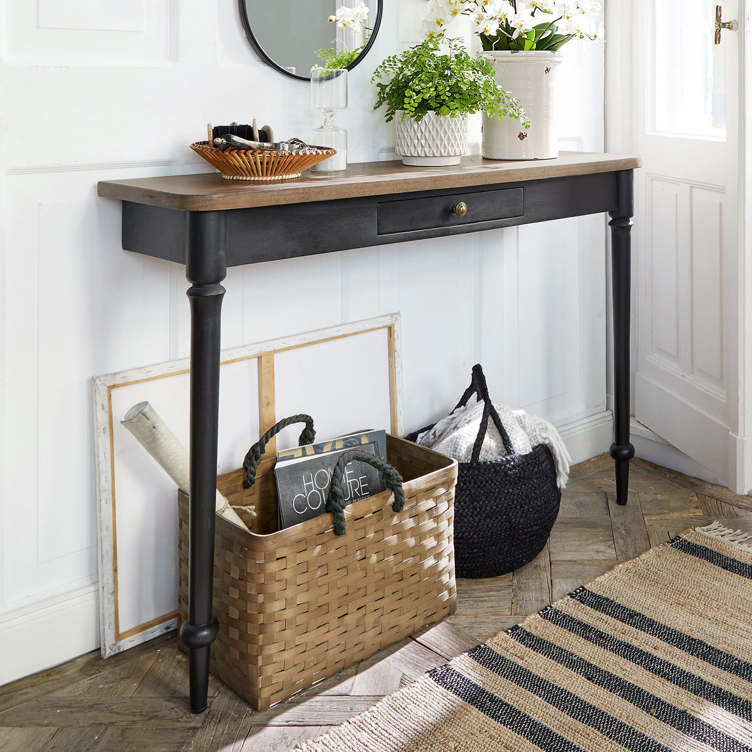 Sidetable Jarobrod Zwarte sidetable met houten blad in lichte kamer met opbergmanden en planten