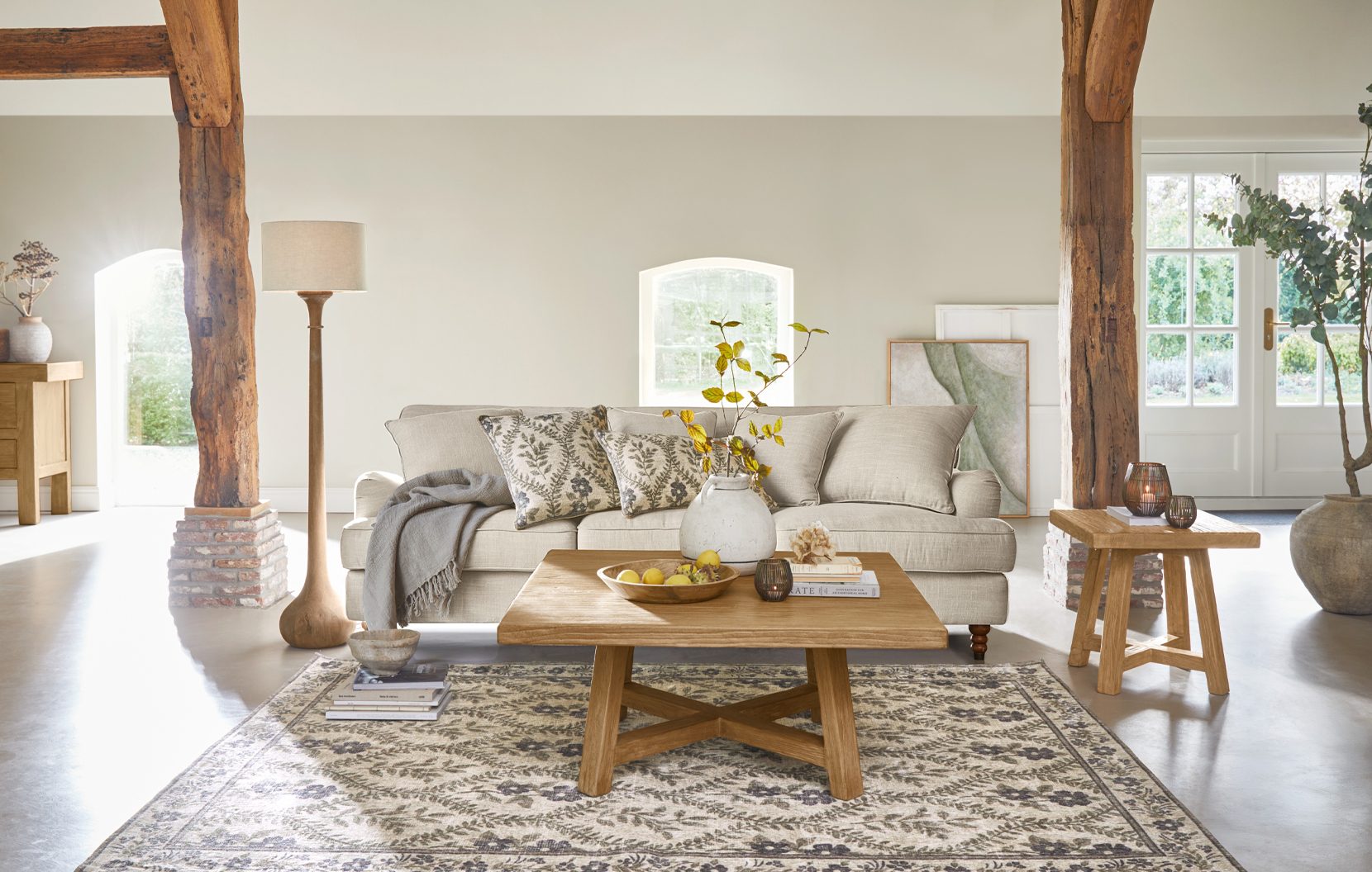 Salon chaleureux style campagne avec canapé beige, table basse en bois et tapis à motifs naturels