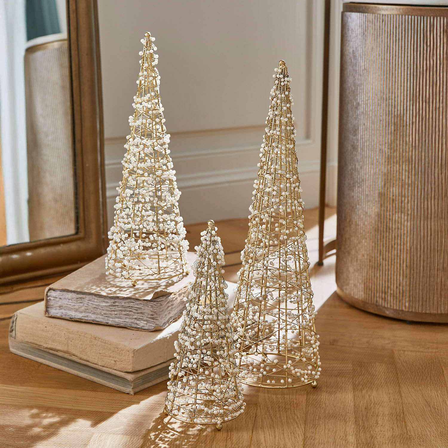 Decoratieve boom set van 3 Amelioro Set van drie decoratieve gouden draadkegels met witte parels op een houten tafel