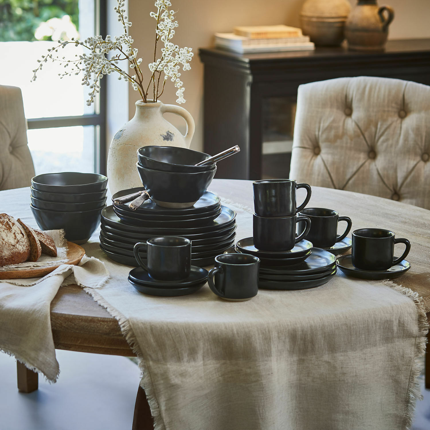 Servies set van 30 Biarré Set zwart keramisch servies op houten dienblad in lichte keuken met natuurlijke accenten