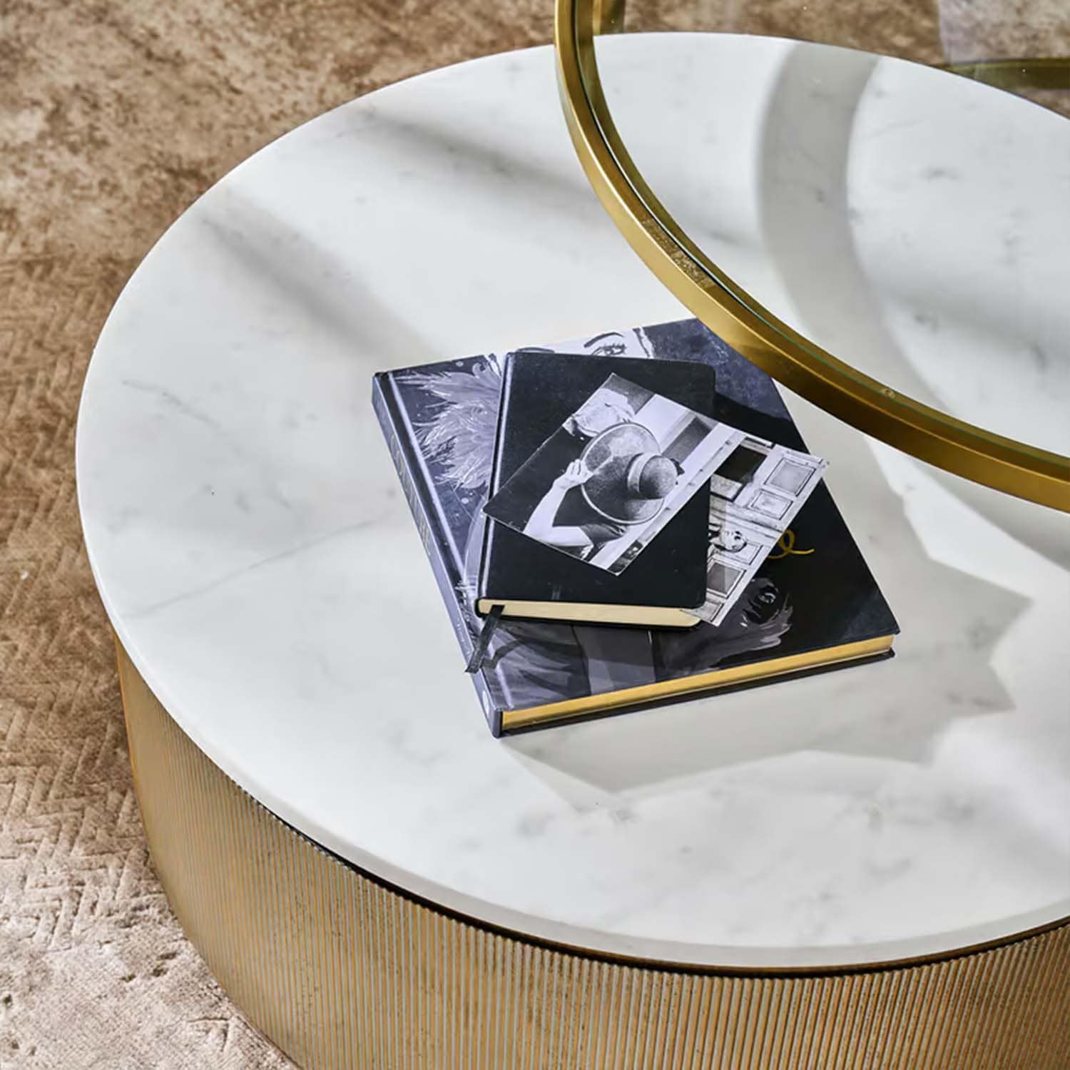 Table basse ronde avec plateau en marbre blanc et base dorée sur tapis beige