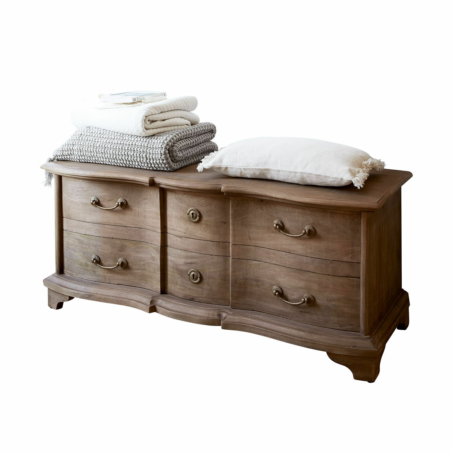 Malle Aiguillon Commode en bois avec façades ondulées et poignées en métal, décorée de coussins et plaids