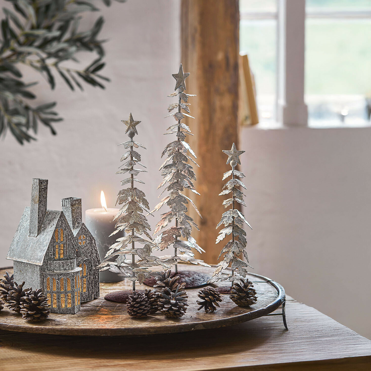 Lot de 3 arbres décoratifs Laruns Décorations de sapins en métal rouillé avec étoiles, posées sur une table en bois rustique
