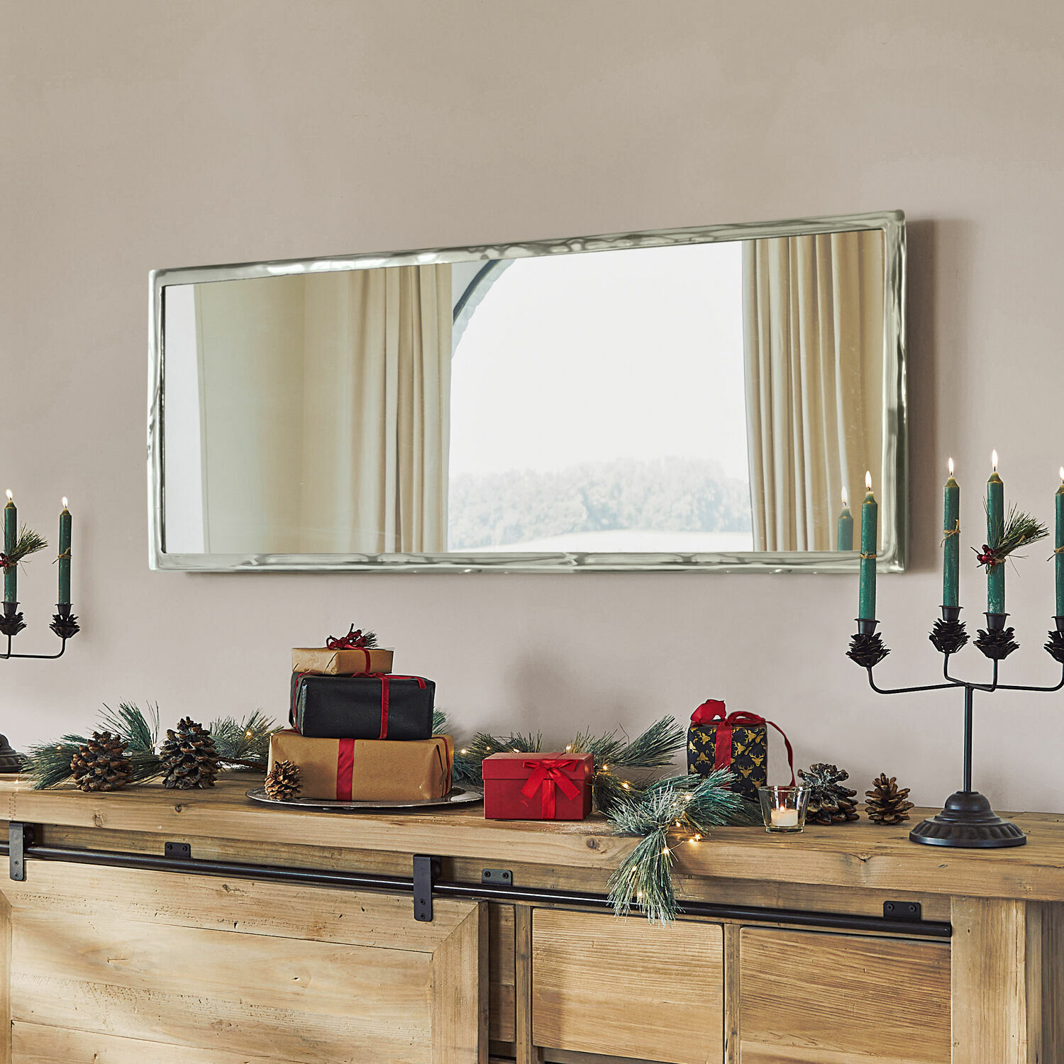 Spiegel Kaplin Rechthoekige spiegel met zilverkleurige metalen lijst boven houten dressoir met kerstdecoratie