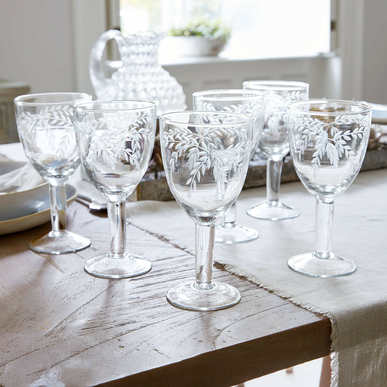 Lot de 6 verres Florineau Ensemble de six verres en verre transparent avec motif de feuilles blanches sur une table à manger