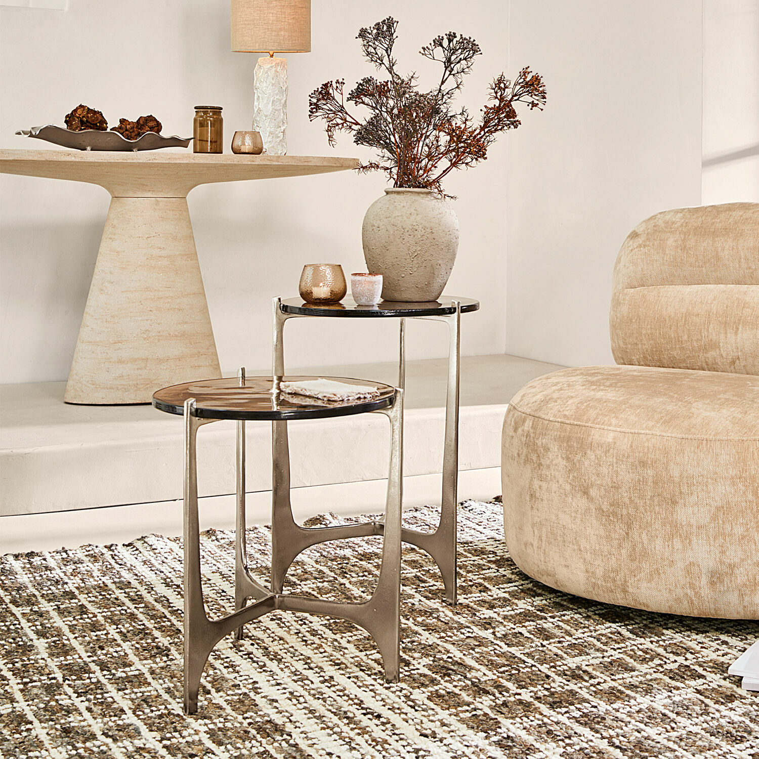 Lot de 2 tables d’appoint Jouvènne Ensemble de deux tables d'appoint avec cadre métallique et plateau foncé sur tapis dans un salon