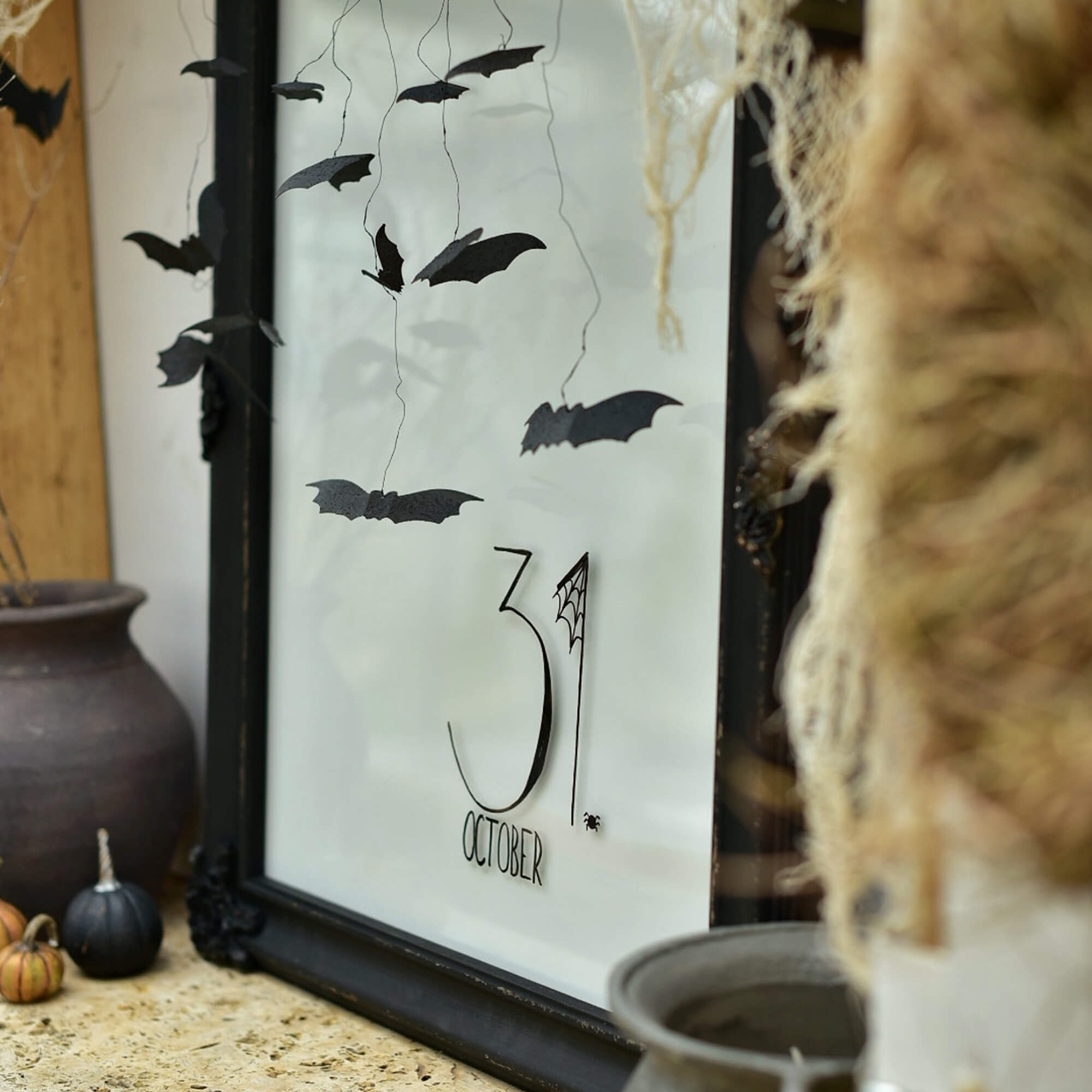 Halloweenversiering met zwarte papieren vleermuizen en tekst 31 oktober in lijst