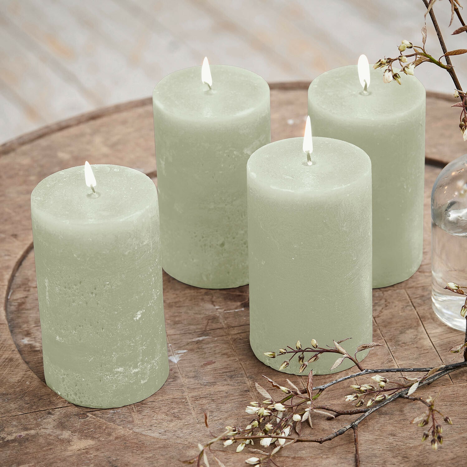 Kaars set van 4 Braga Set van vier groene waskaarsen op houten tafel met bloemendecoratie