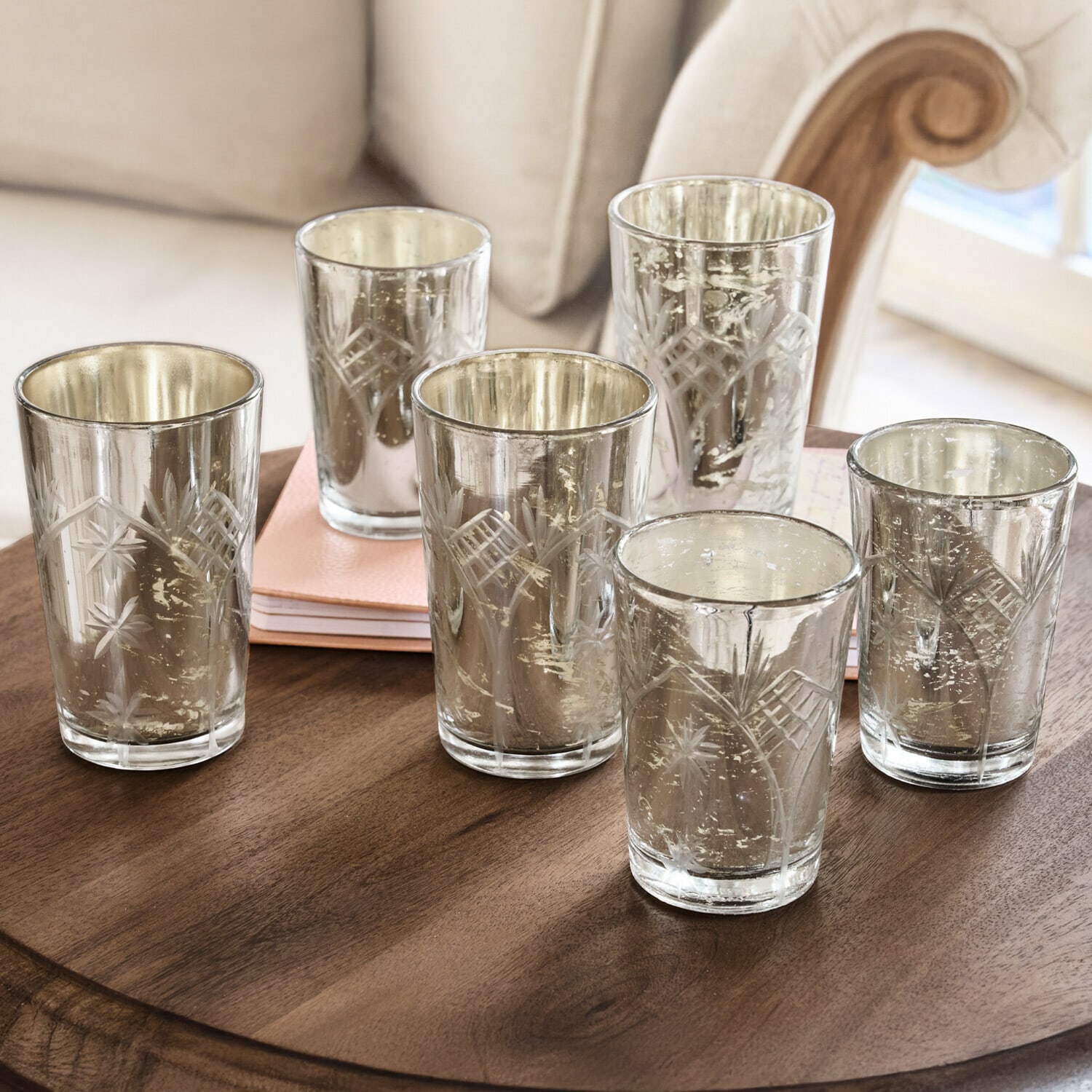 Lot de 6 photophores Latona Ensemble de six photophores en verre gravé avec finition argentée posés sur une table en bois