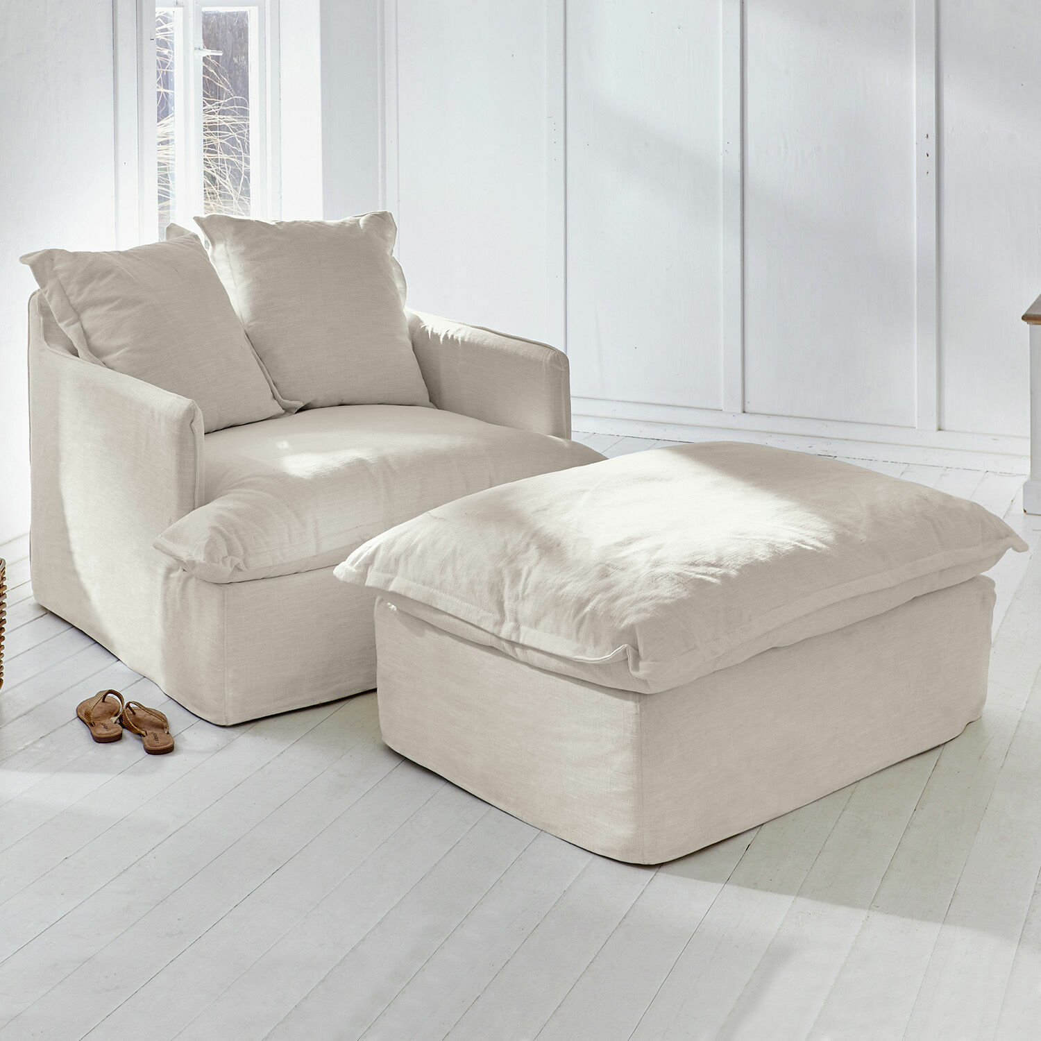 Fauteuil et repose-pieds beige en tissu dans un intérieur lumineux et naturel pour se détendre