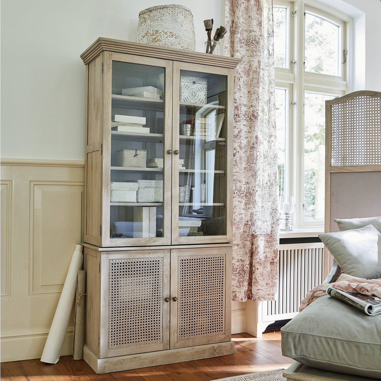 Vitrine en bois clair avec portes vitrées et en osier pour un salon lumineux et élégant