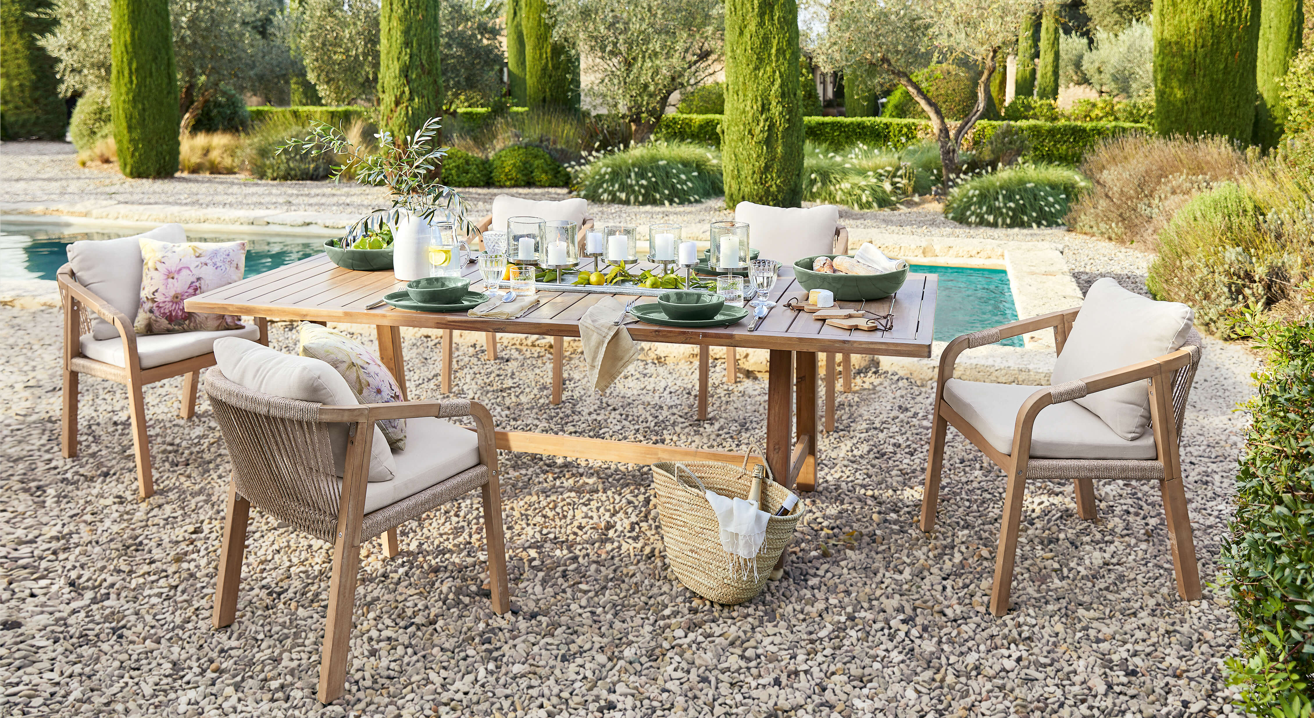 Tuinmeubelset met houten tafel en beige stoelen op grindterras bij zwembad