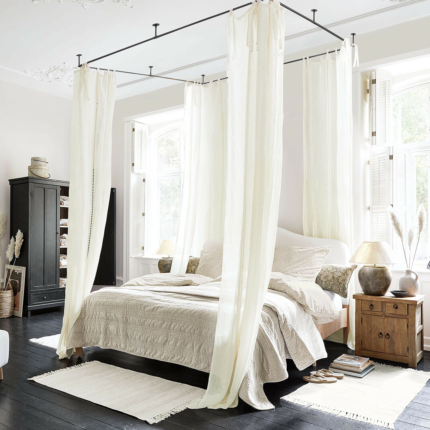 Rideau Elorine Chambre avec lit à baldaquin en coton blanc et literie beige sur parquet foncé, ambiance lumineuse naturelle