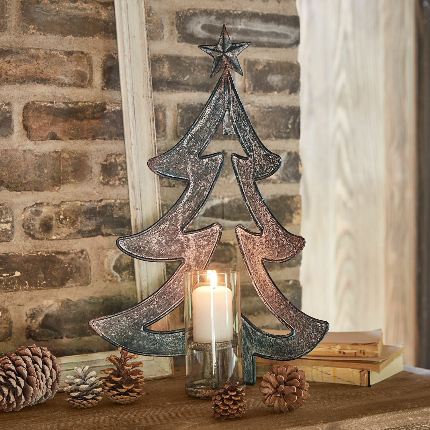 Wandkaarsenhouder Jolise Metalen kerstboomdecoratie met ster en kaars in glazen houder op houten tafel met dennenappels