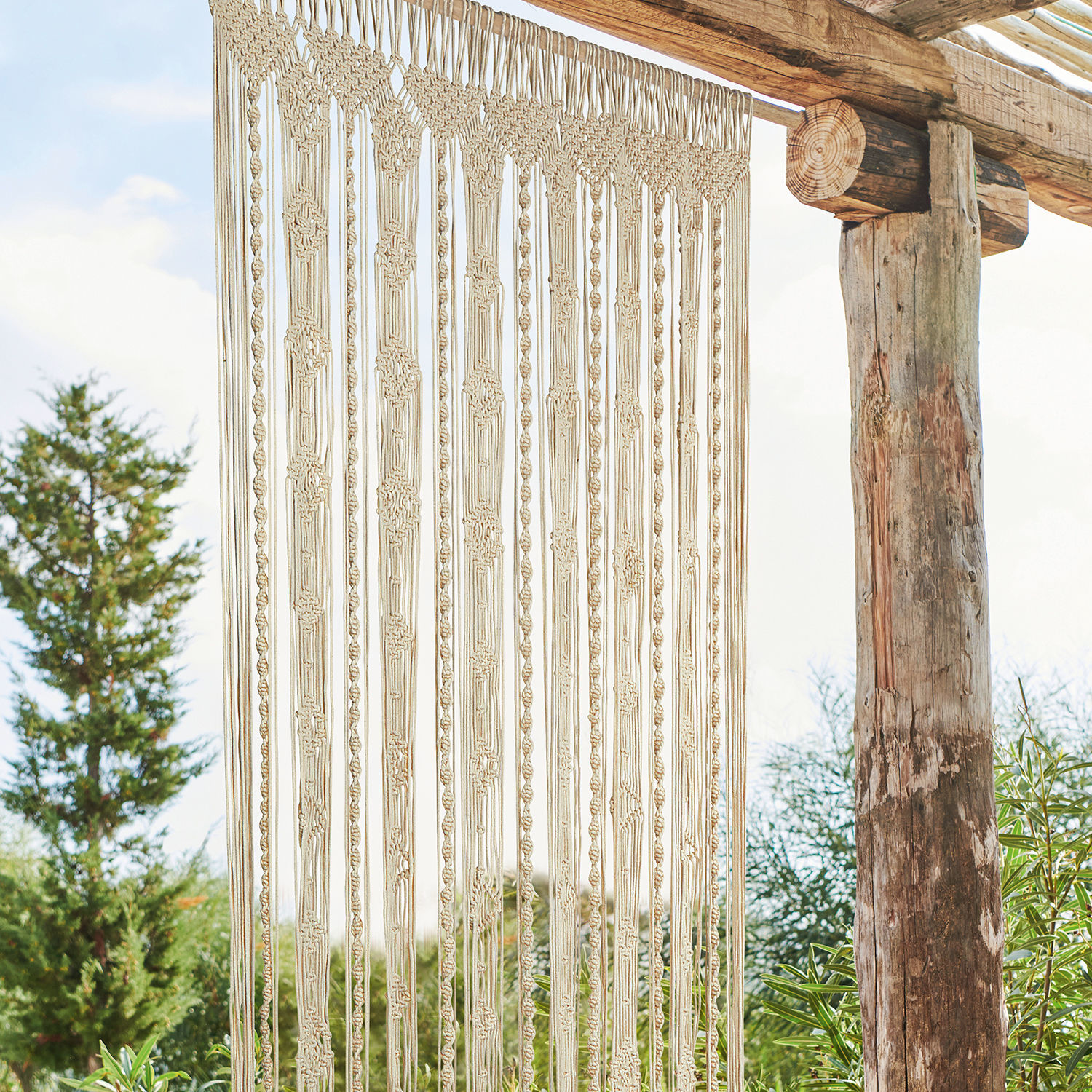 Rideau Arjun Macramé beige en coton suspendu sur une structure en bois, décoration murale pour intérieur et jardin