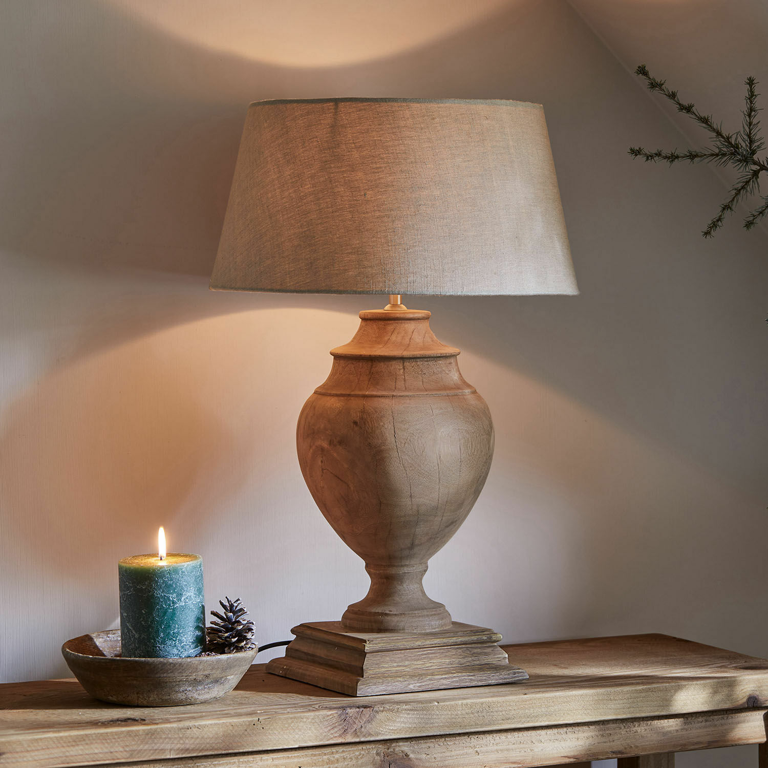 Lampe à poser Sauverny Lampe de table avec base en bois et abat-jour beige sur table en bois, bougie décorative à côté