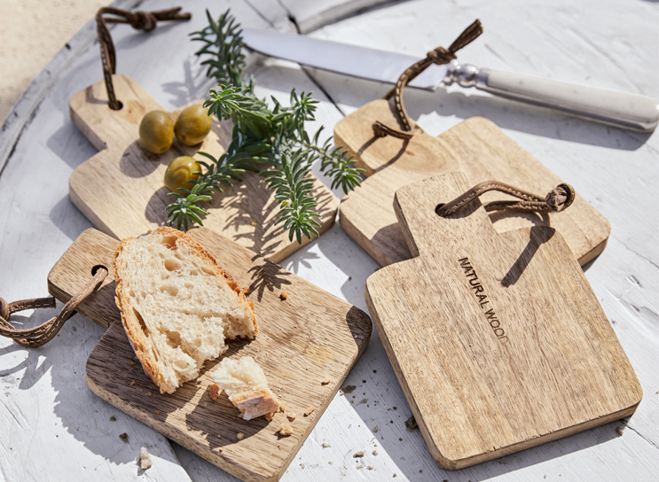 Set houten snijplanken van natuurlijk hout met brood en olijven op witte tafel in mediterrane stijl