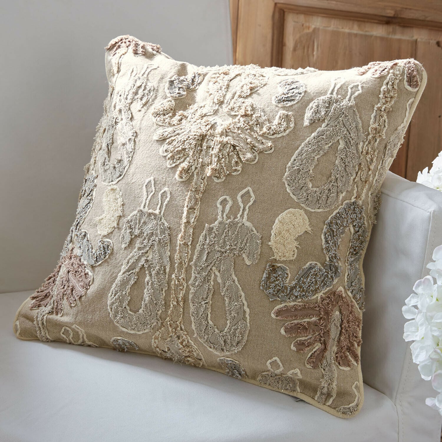 Kussenhoes Rahmira Beige sierkussen met geborduurd patroon in natuurlijke kleuren op witte bank