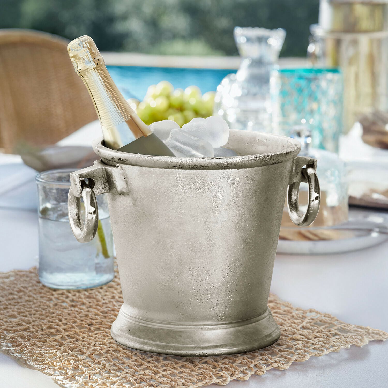 Drankenkoeler Cressford Zilverkleurige metalen ijsemmer met champagnefles en ijs op tuintafel