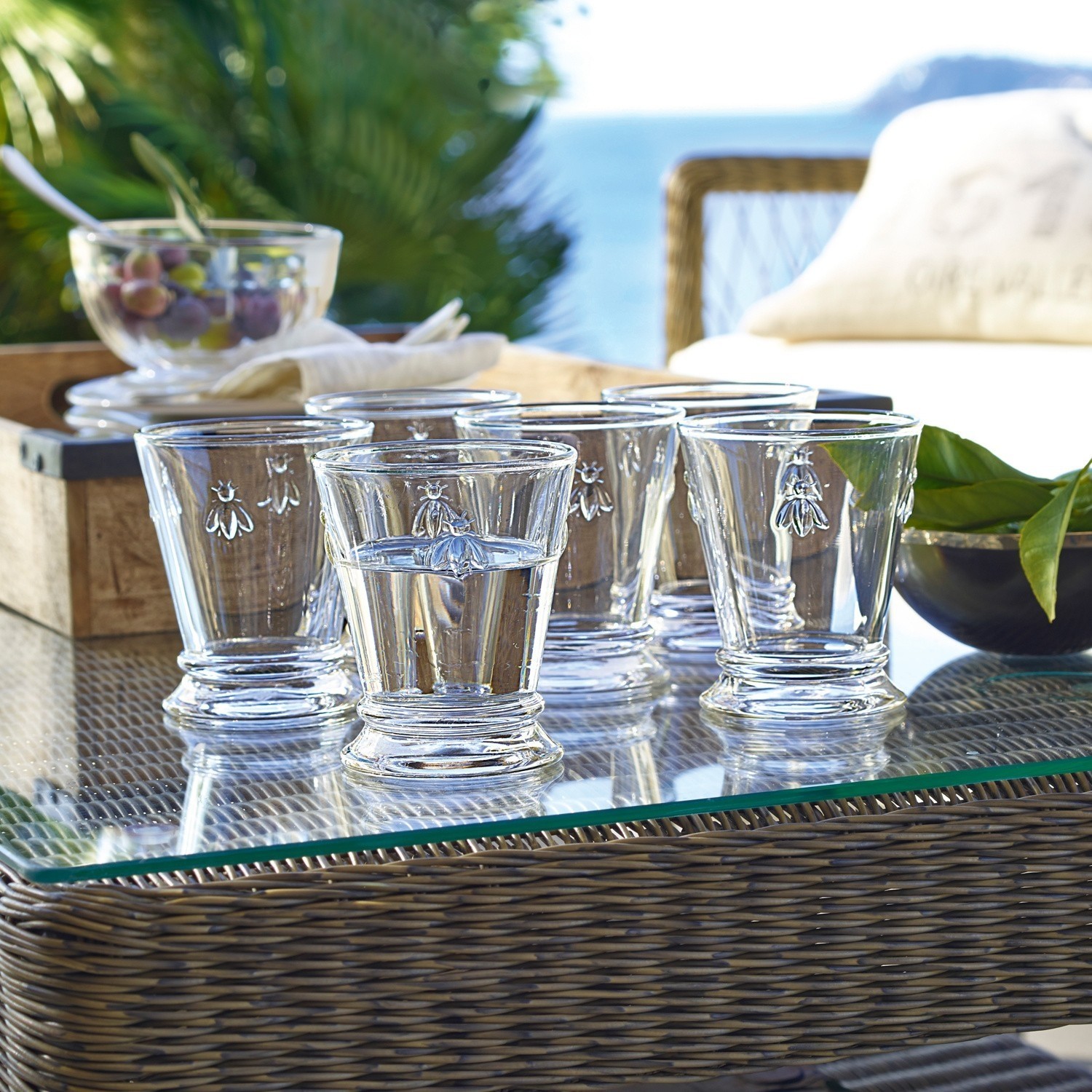 Waterglas set van 6 Abeille Set van zes heldere glazen met bijmotief op glazen tafel buiten