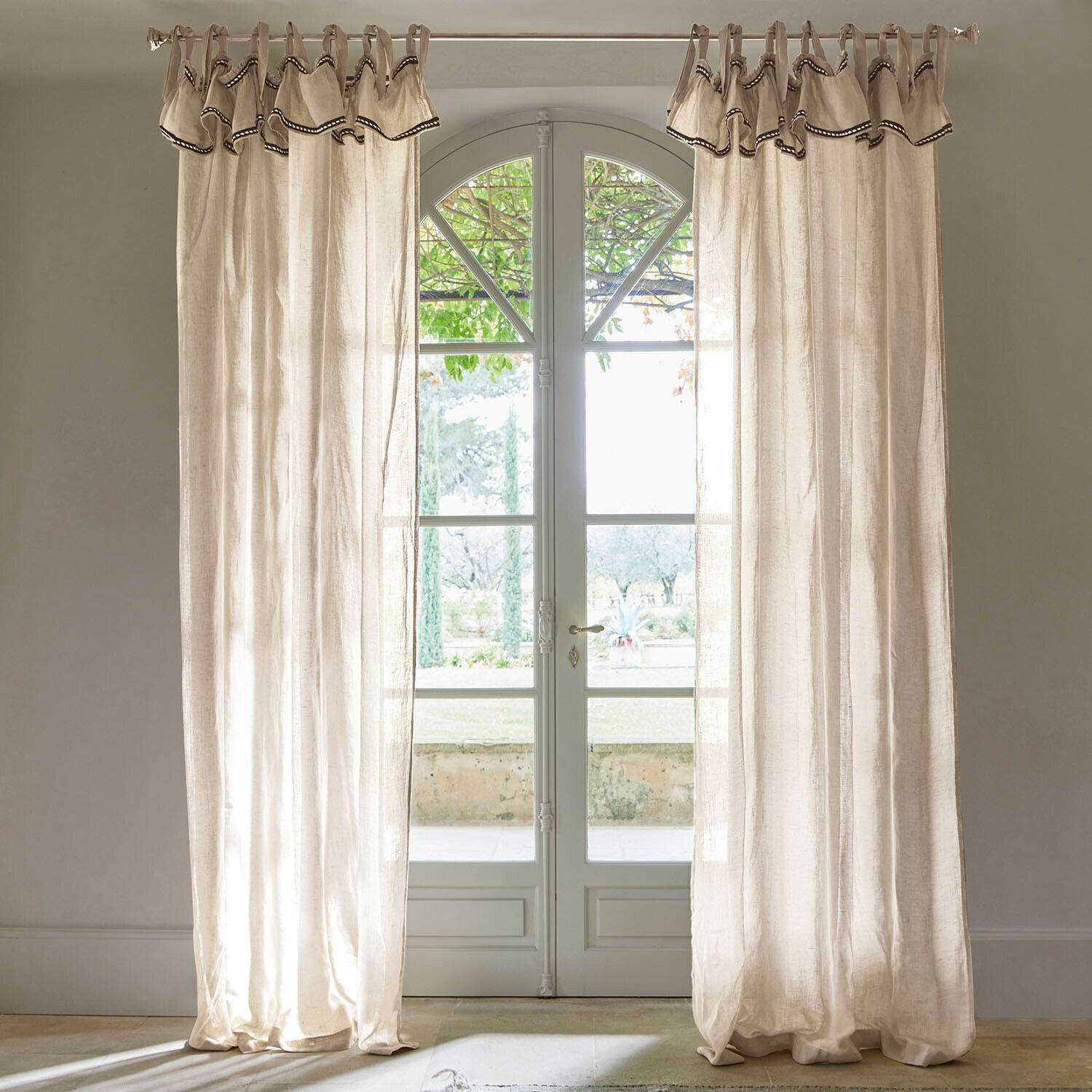 Gordijn Romagny Beige linnen gordijnen met decoratieve rand aan raam met uitzicht op tuin, interieurdecoratie