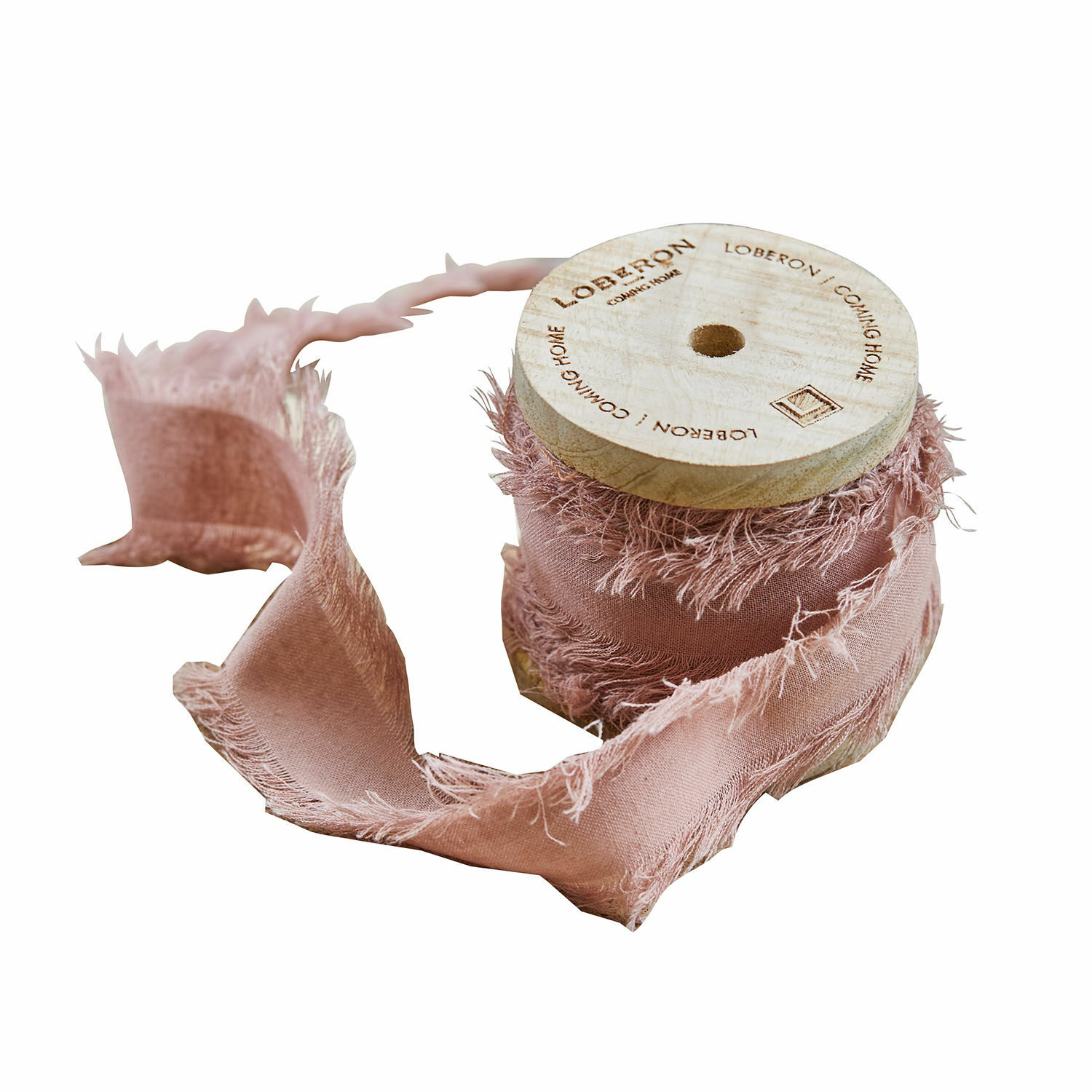 Ruban décoratif en coton rose avec bords effilochés sur bobine en bois naturel