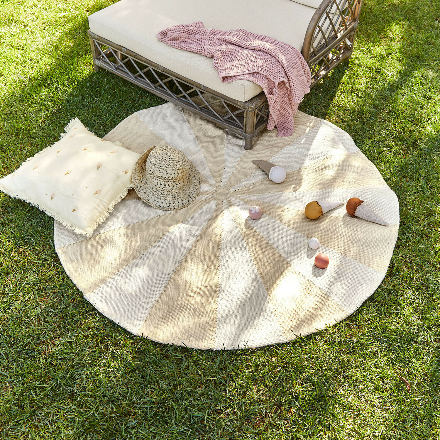 Vloerkleed voor binnen en buiten Wobbilo Ronde vloerkleed van natuurlijk materiaal in beige-crèmekleuren op gras met kussen en strohoed