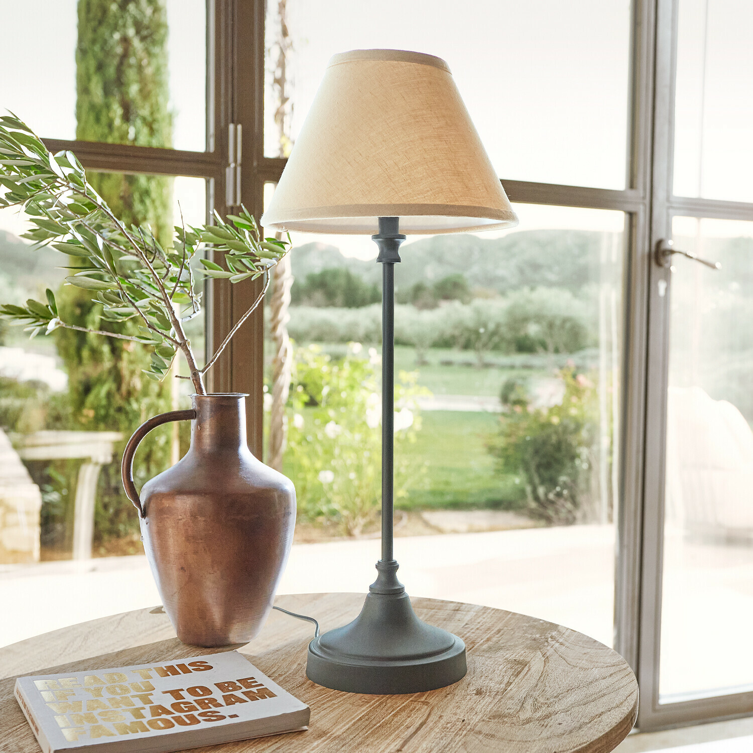 Lampe à poser Swindon Lampe de table avec base en métal et abat-jour beige sur table en bois avec vase et livre