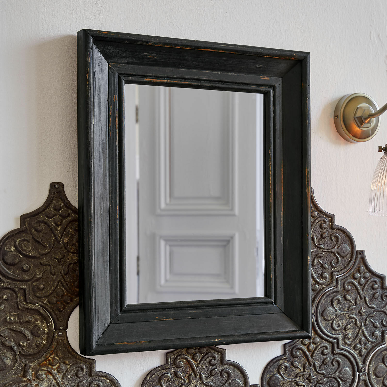 Miroir Orlise Miroir carré avec cadre en bois noir vieilli sur un mur avec panneaux métalliques décoratifs