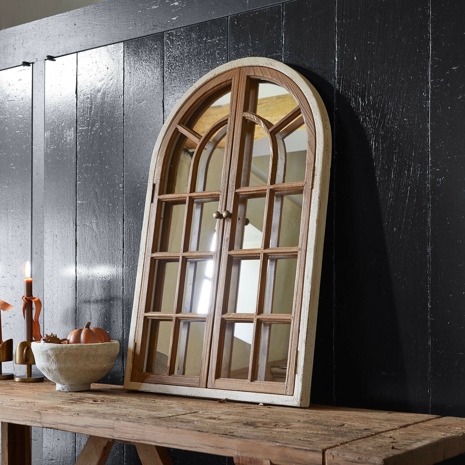 Siervenster met spiegel Montévine Houten spiegel in raamvorm met wit frame op rustieke tafel tegen zwarte muur