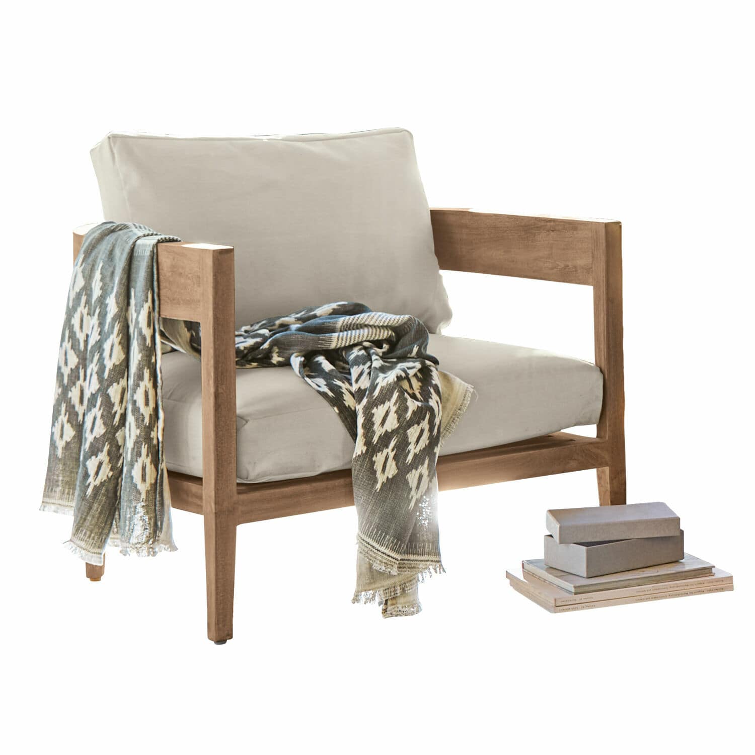 Fauteuil Courtelevant Fauteuil met lichtbeige bekleding en houten frame, versierd met een patroon sjaal en boeken ernaast