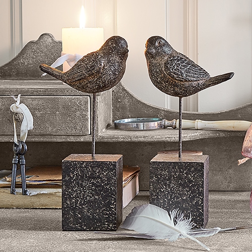 Decoratieve metalen vogelbeelden op vierkante sokkels in vintage stijl voor interieurdecoratie