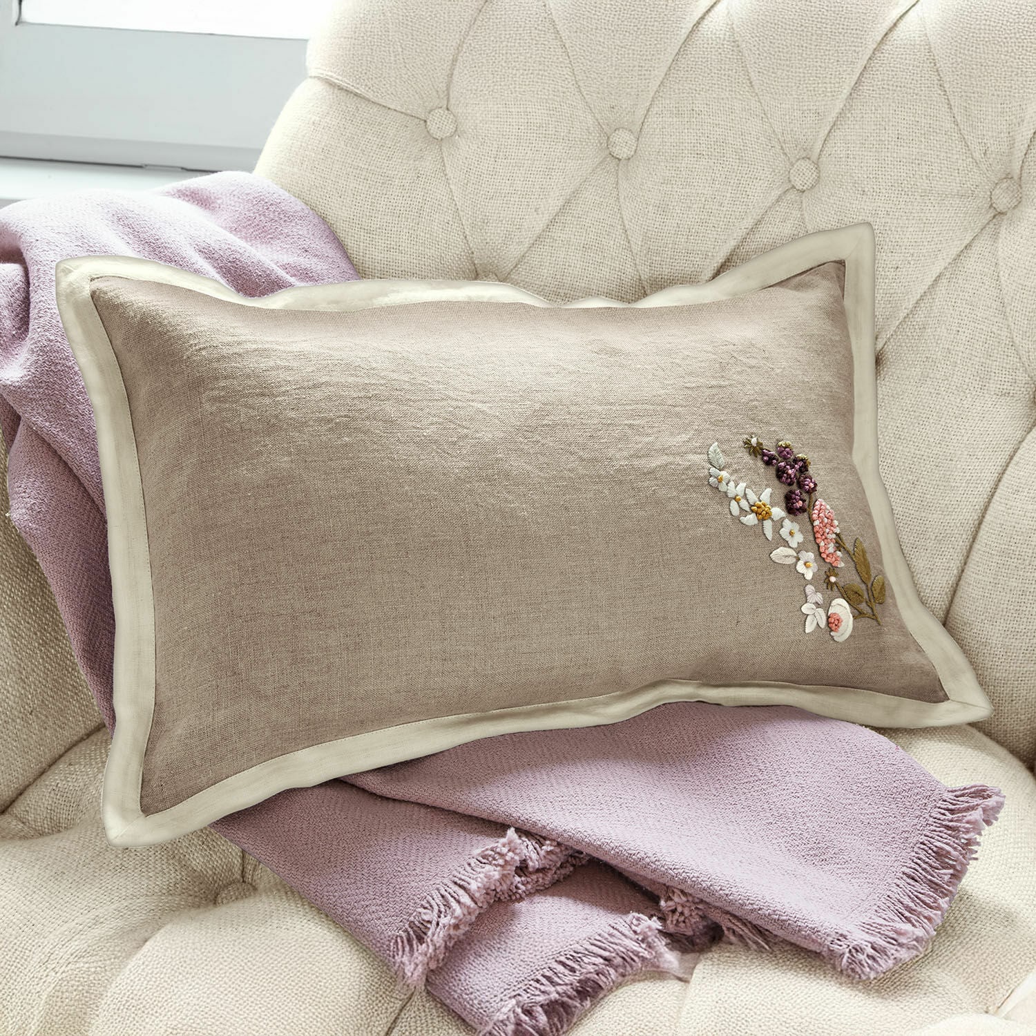 Kussenhoes Tavaline Beige linnen kussen met bloemenborduursel op lichtroze deken op stoel, interieurdecoratie