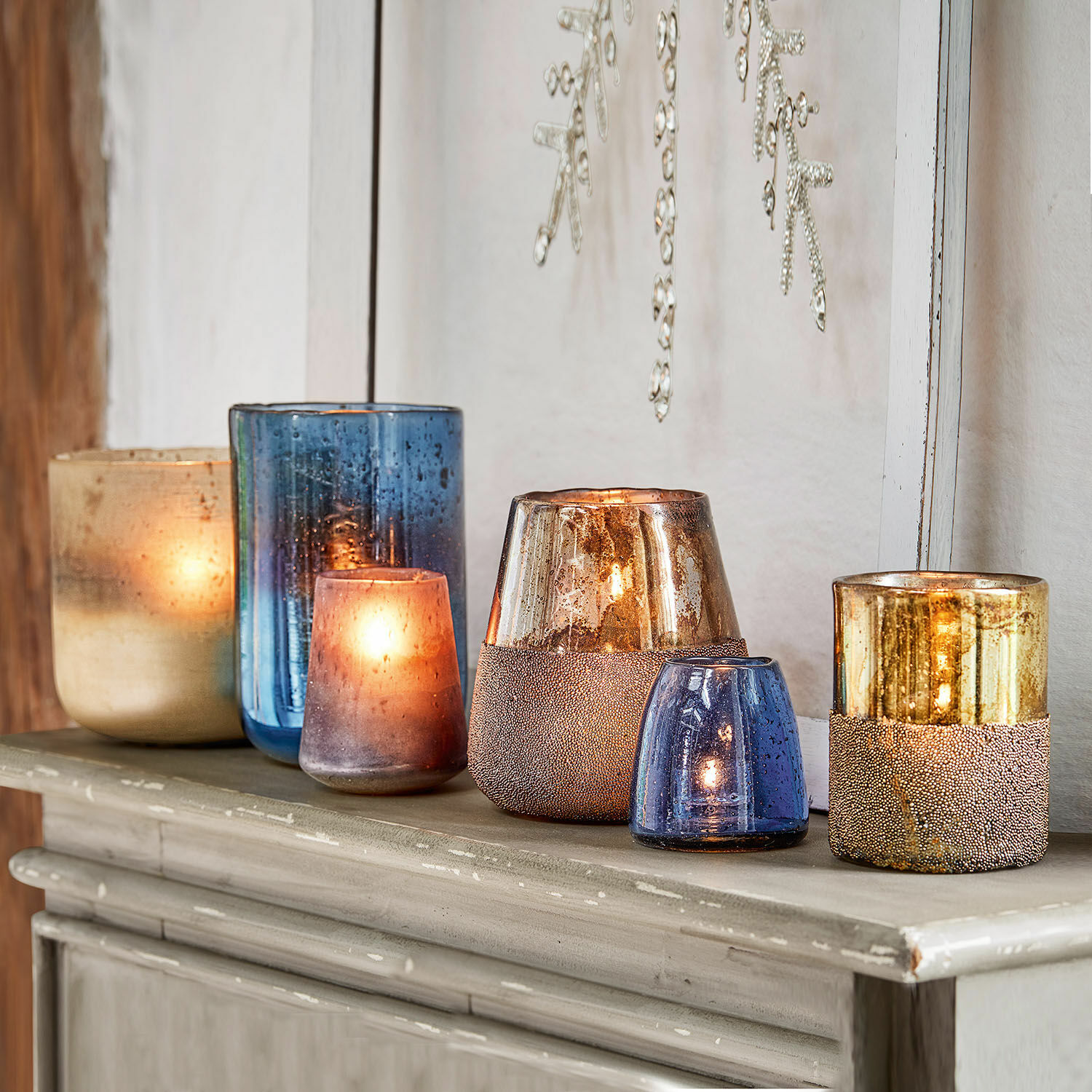 Ensemble de photophores en verre bleu et doré sur une commode, décoration intérieure élégante