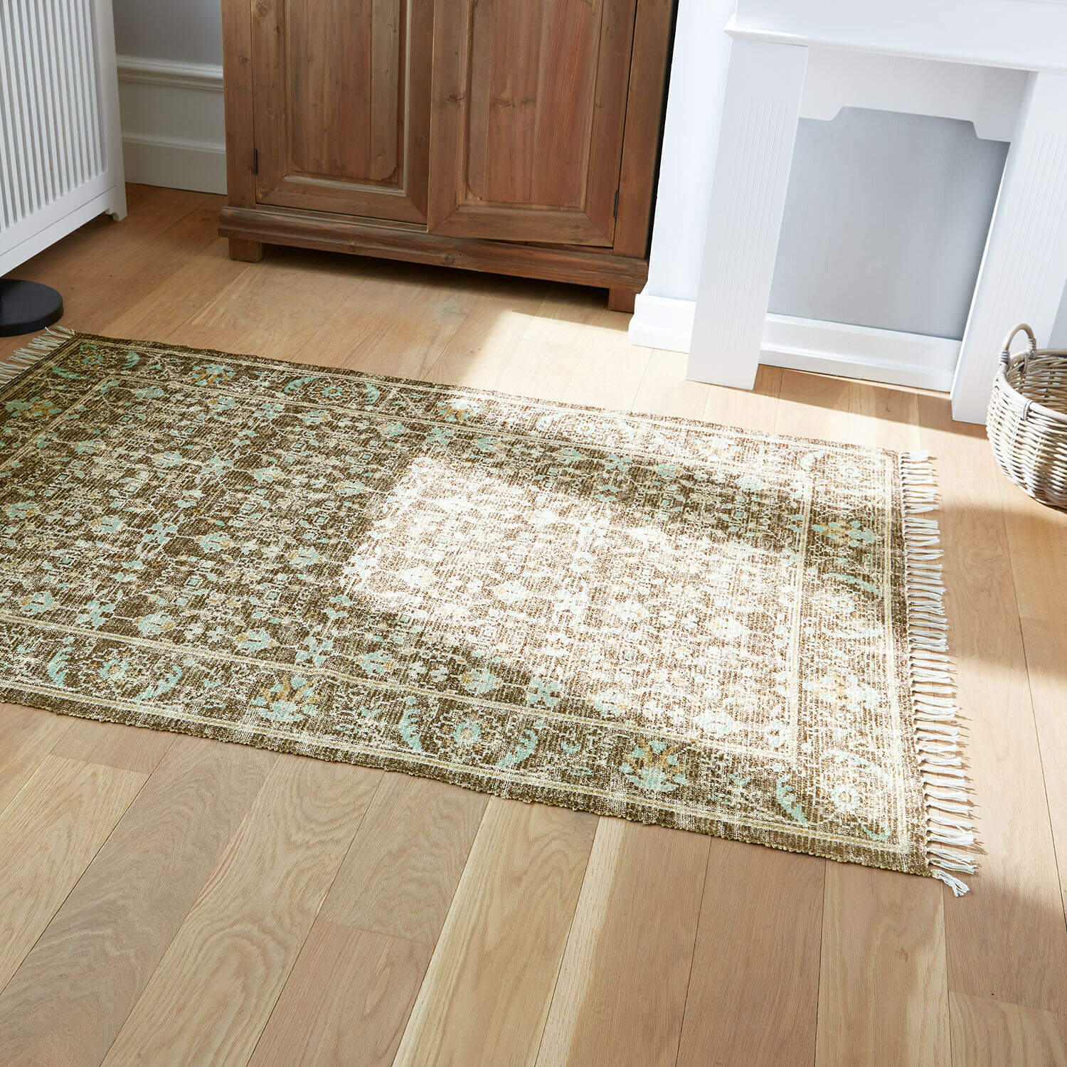 Vloerkleed voor binnen en buiten Zemira Vloerkleed met bruin-groen patroon op lichte houten vloer in een lichte woonkamer