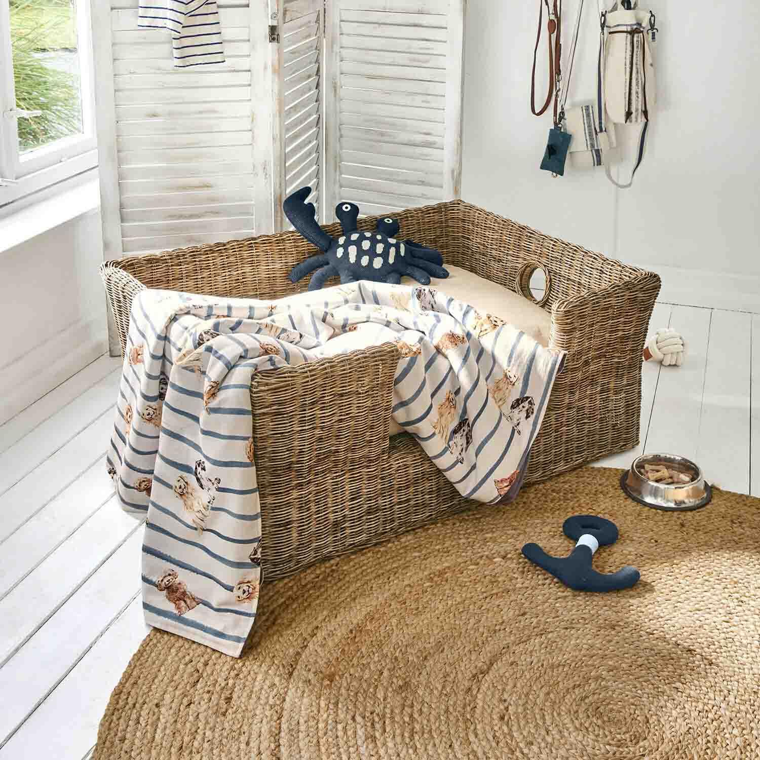 Rieten hondenmand met beige kussen, gestreept hondenprint deken, speelgoed en voerbak