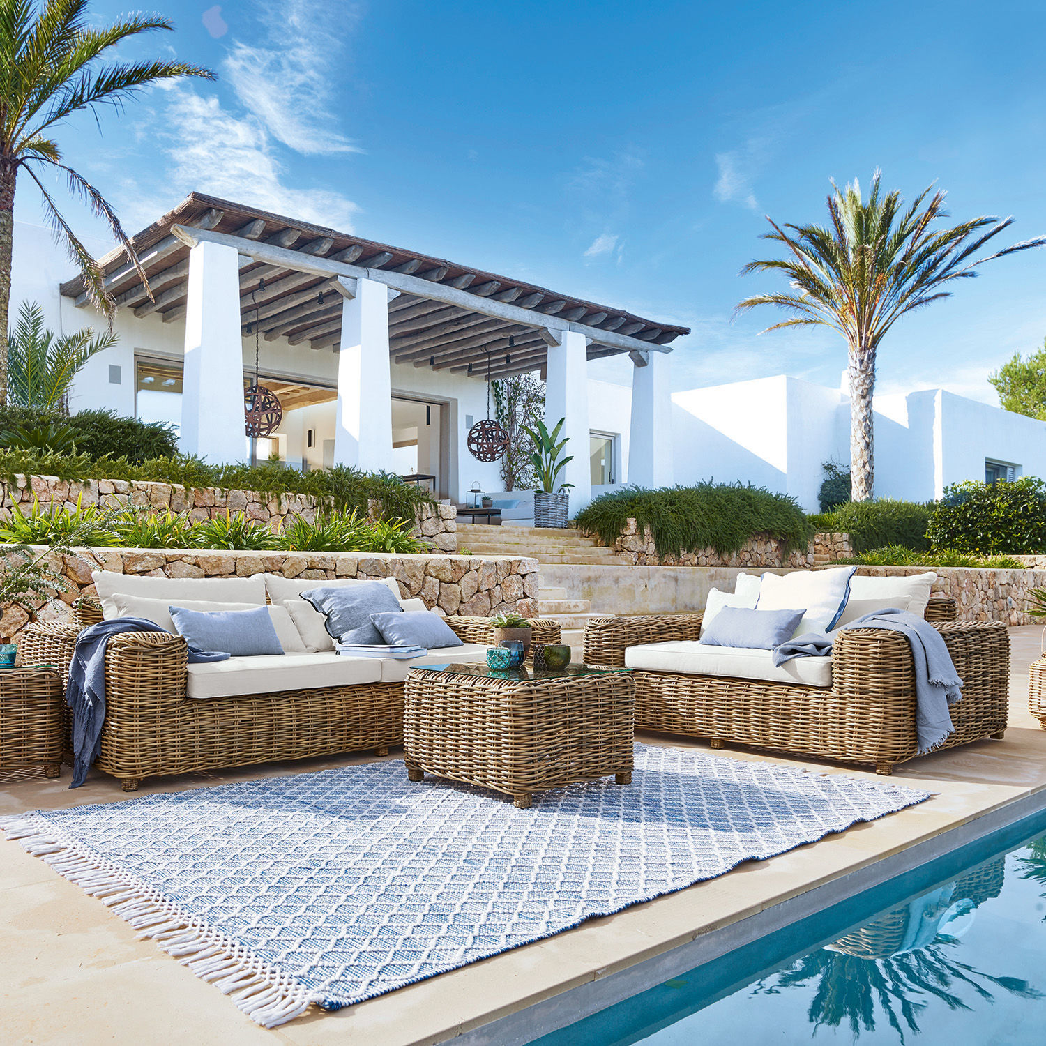 Ensemble canapé et fauteuil Camas Ensemble de mobilier de jardin en rotin naturel avec coussins crème au bord de la piscine