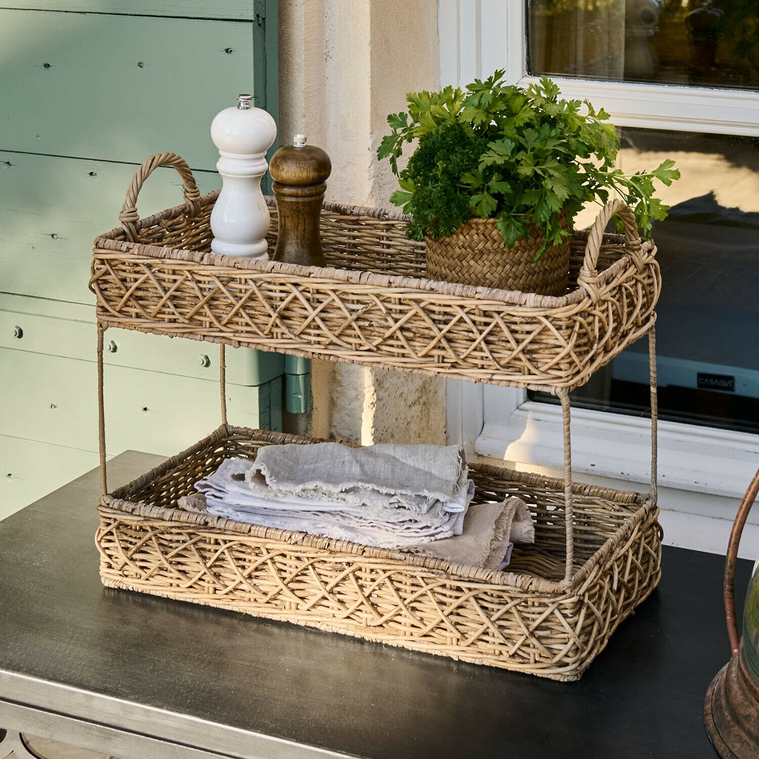 Présentoir Mossbury Panier à deux niveaux en rotin naturel avec épices et herbes fraîches sur une table