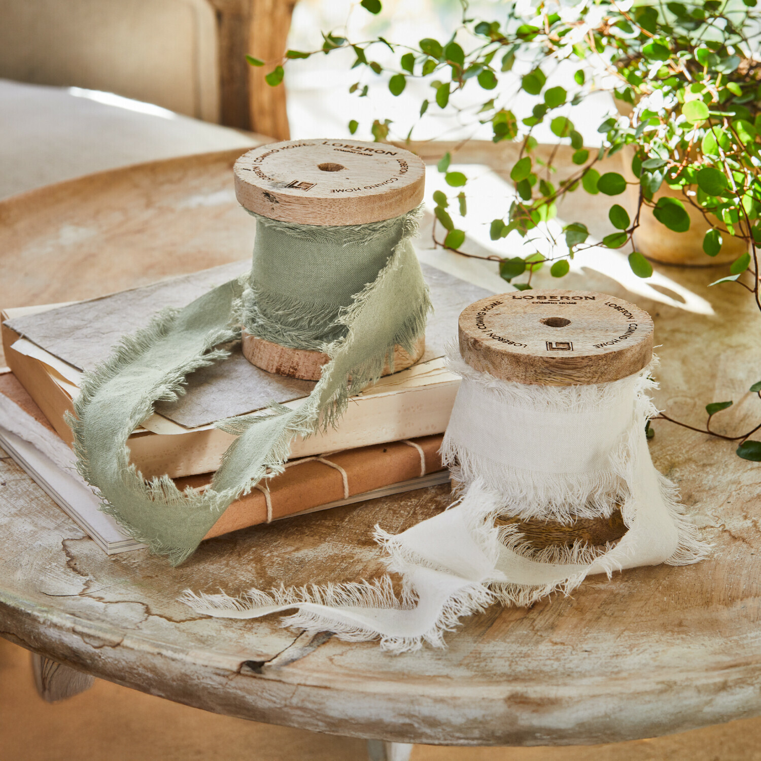 Lint set van 2 Valethor Twee houten spoelen met wit en groen linnen lint op rustieke houten tafel