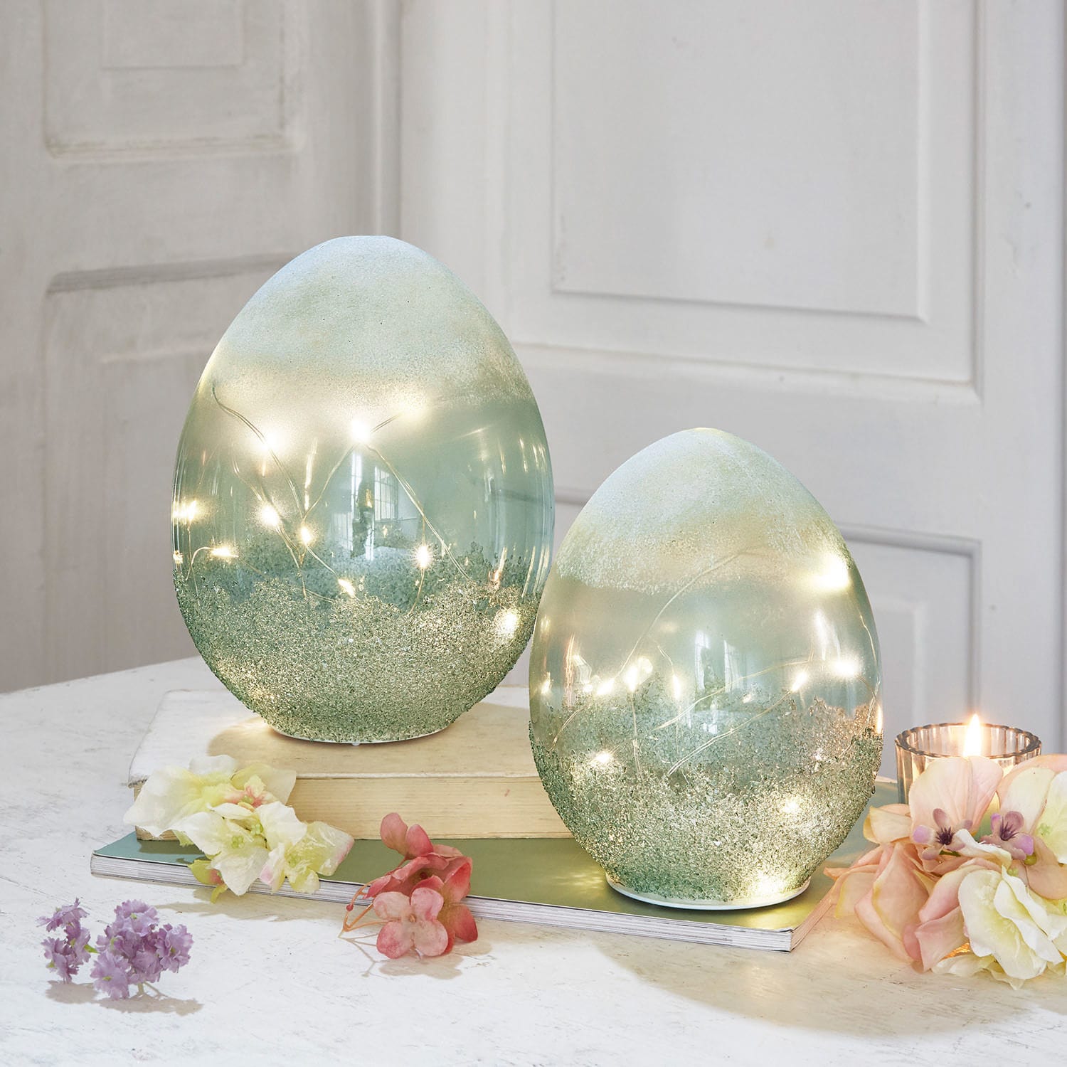 LED-ei set van 2 Borleos Decoratieve groene glazen eieren met ingebouwde LED-lichtjes op tafel met bloemen en kaars