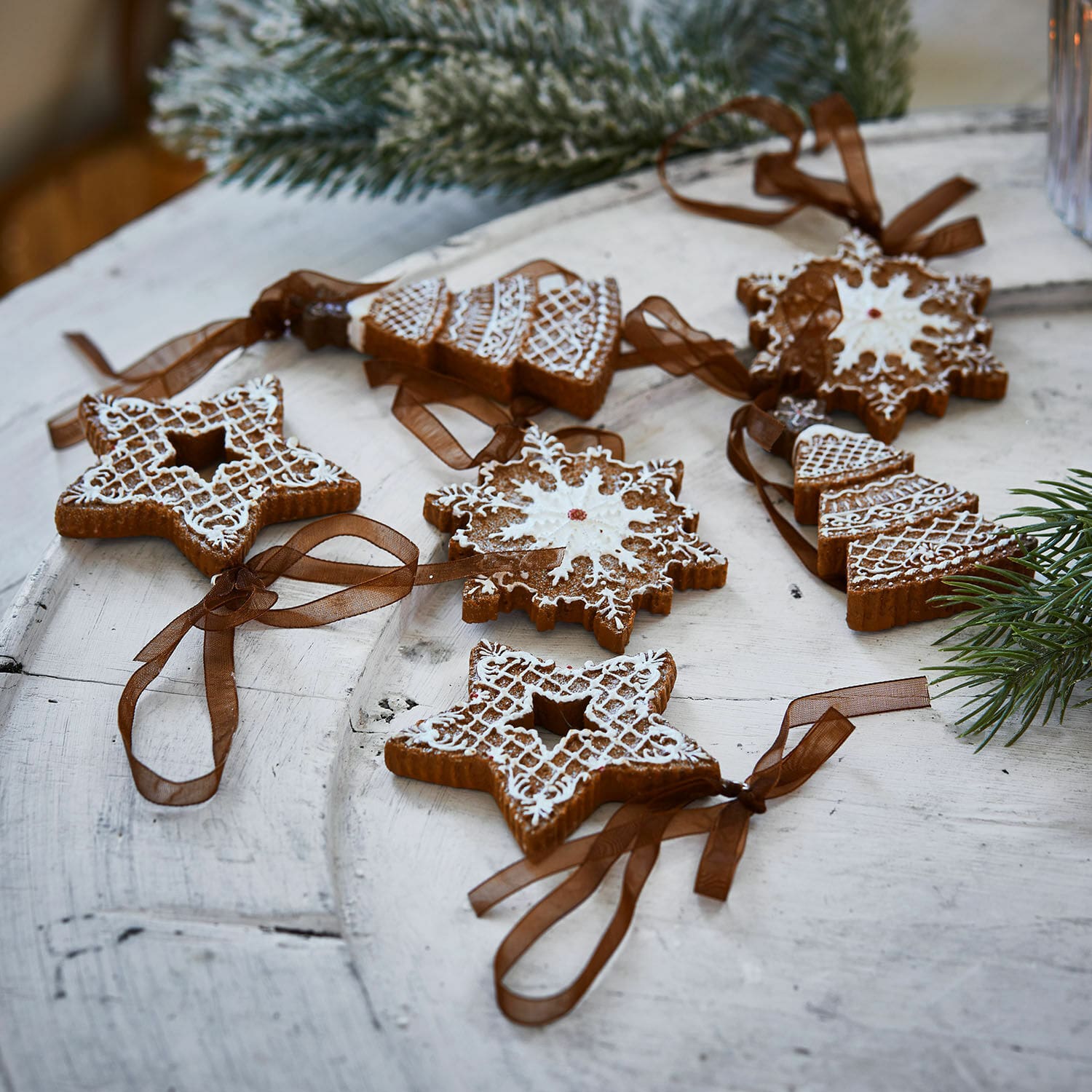 Hanger set van 6 Chimayo Set kerstversieringen van peperkoek met witte glazuur en bruine linten op houten tafel