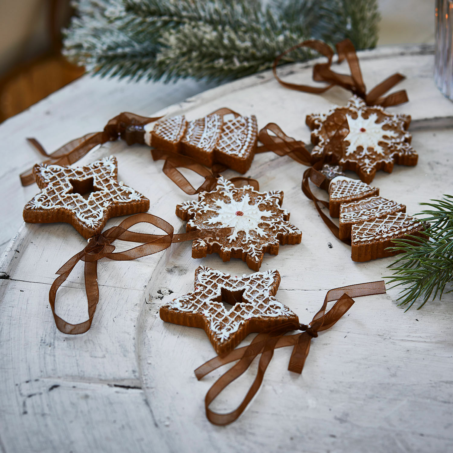 Hanger set van 6 Chimayo Set kerstversieringen van peperkoek met witte glazuur en bruine linten op houten tafel
