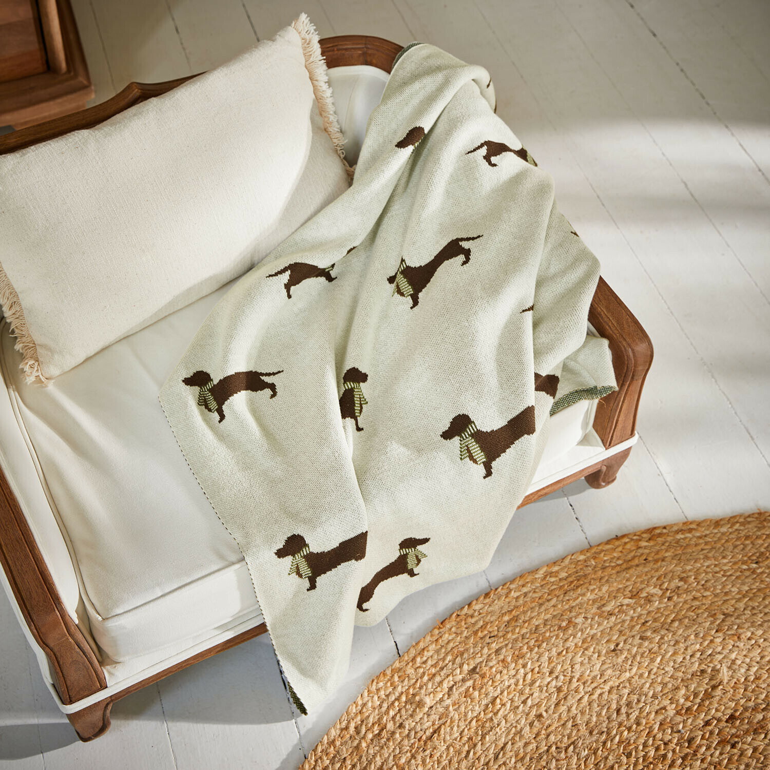 Couverture pour animaux Brisette Plaid beige avec motif de teckel sur canapé blanc en bois avec coussin à franges