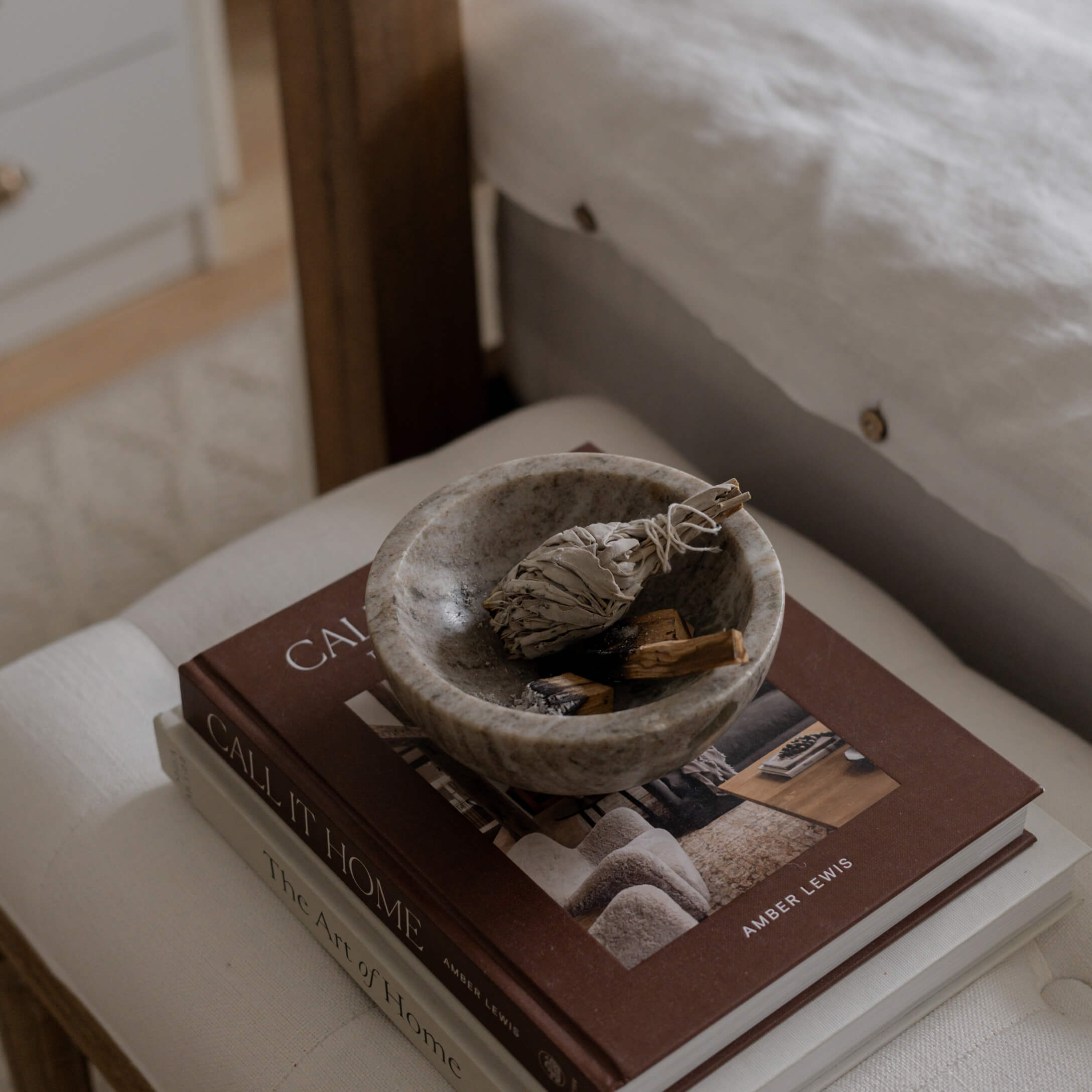 Bol en pierre grise avec des herbes séchées posé sur des livres de décoration intérieure