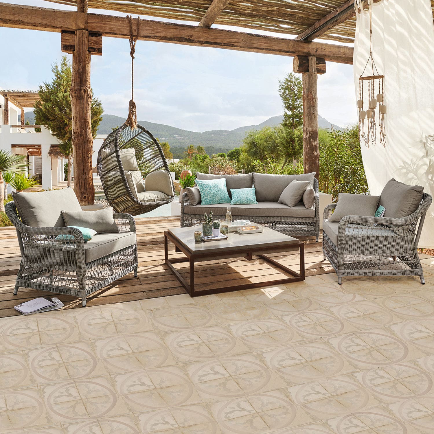 Salon de jardin Tanaiste Ensemble de mobilier de jardin en rotin gris avec coussins et fauteuil suspendu sur terrasse avec vue montagne